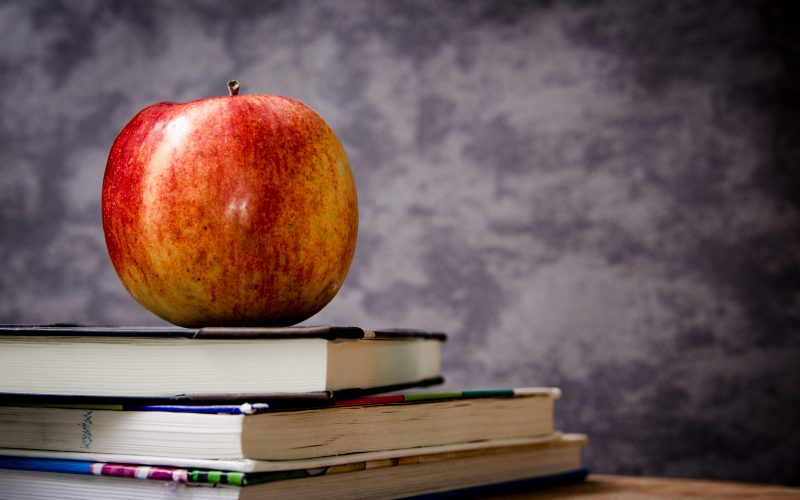 School classroom, apple resting on top of some books