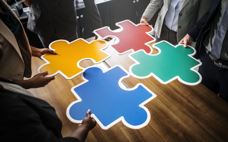 Business people connecting puzzle pieces - who you know is how you get stuff done