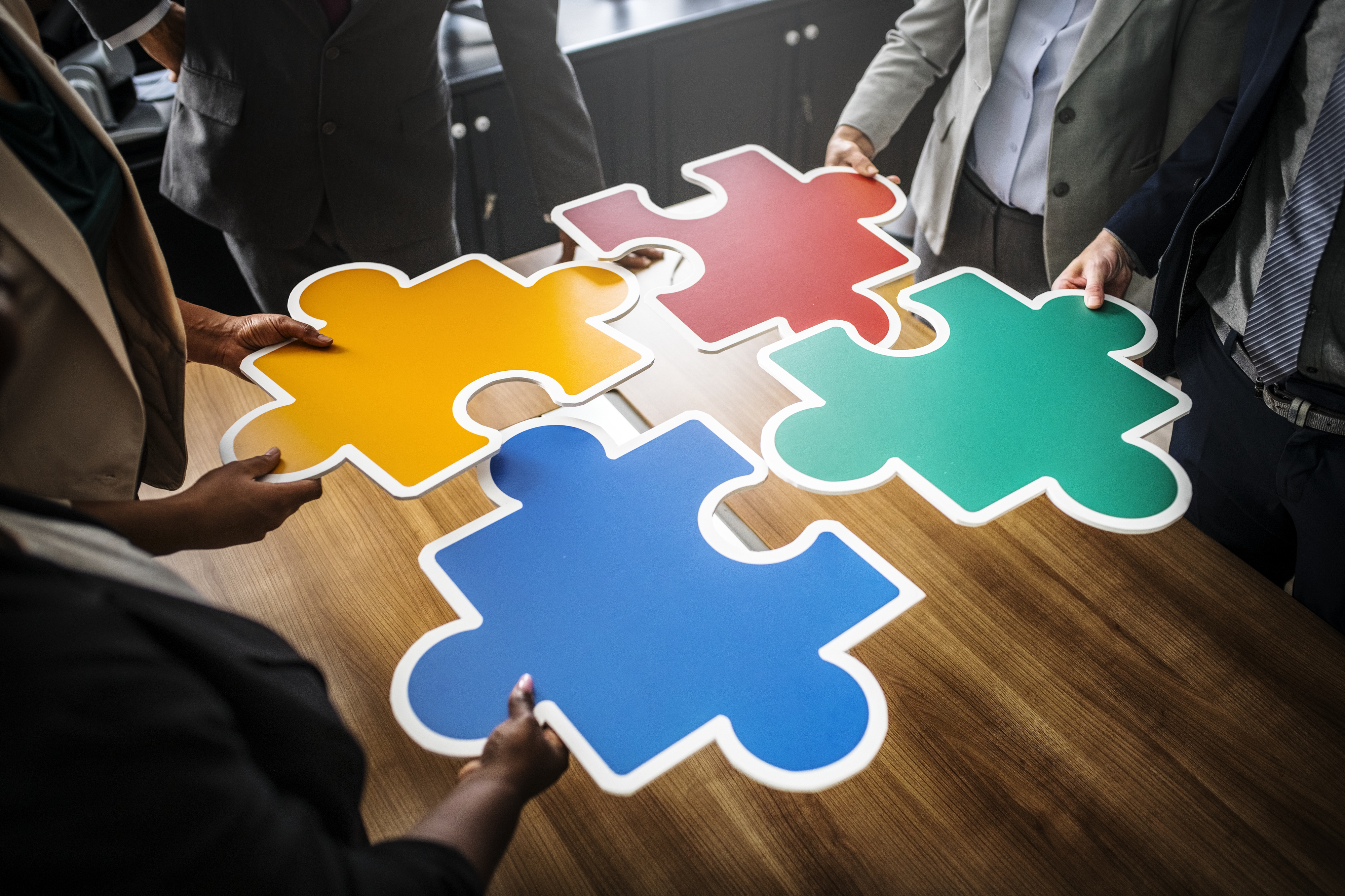 Business people connecting puzzle pieces - who you know is how you get stuff done